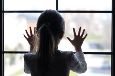 窓から外を眺める少女